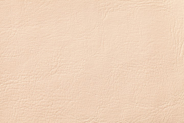 Light coral leather texture background, closeup. Beige cracked backdrop