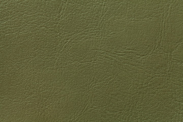 Dark olive leather texture background, closeup. Green cracked backdrop