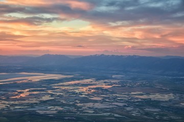 Great Salt Lake Sunset Aerial view from airplane in Wasatch Rocky Mountain Range, sweeping cloudscape and landscape during day time in Spring. In Utah, United States.