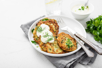 Zucchini fritters or pancakes with yogurt dressing with fresh herbs.