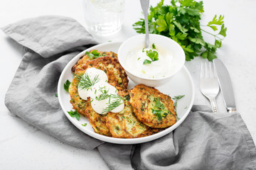 Zucchini fritters or pancakes with yogurt dressing with fresh herbs.