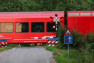 train on railway passing railoradcrossing with cyclists