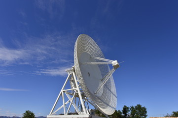 Array of satellite dishes or radio antennas against sky. Space observatory.
