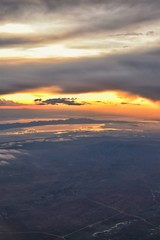 Naklejka na ściany i meble Great Salt Lake Sunset Aerial view from airplane in Wasatch Rocky Mountain Range, sweeping cloudscape and landscape during day time in Spring. In Utah, United States.
