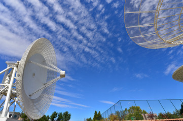 Array of satellite dishes or radio antennas against sky. Space o