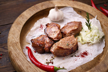 Grilled pork meat with marinated onions garnishing on wooden board. Summer delicious food, weekend bbq party, picnic food
