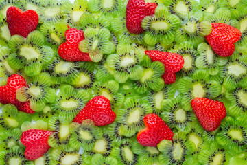 top view of funny creative concept sliced kiwi flower shape and strawberry heart shape like background