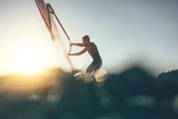 Fototapeten Low angle splashing view of windsurfer sailing on windsurf board © yossarian6