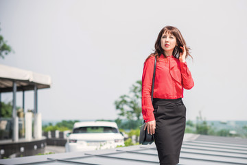 Fototapeta premium Business woman in city wear red shirt and black skirt, bussinestyle for women 