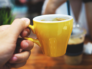 hand holding coffee cup and smartphone in the cafe