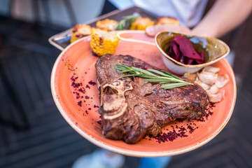 grilled sliced steak and rosemary on plate. serving dishes in the restaurant