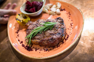 grilled sliced steak and rosemary on plate. serving dishes in the restaurant