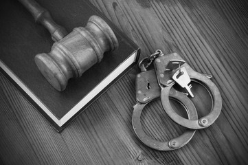 Legal book, wooden judge gavel and handcuffs with keys on table, crime and law concept