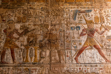 Fototapeta premium Ancient hieroglyphs and relief engravings carved into a stone wall at Luxor Temple of Amun-Ra
