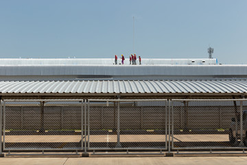 worker painting on the roof of factory 