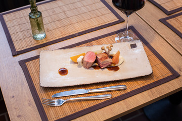 Rind Fleisch auf rechteckigem Teller mit Wein