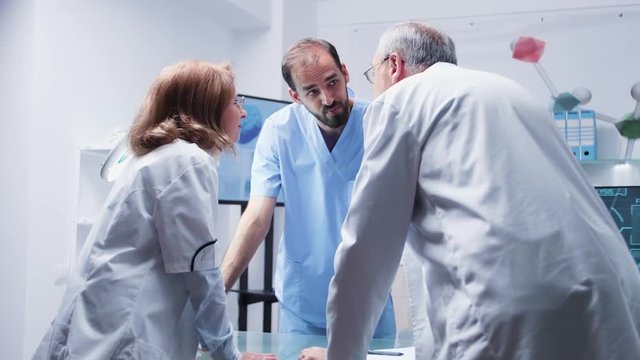 Group of scientists and an assitant are talking in modern and high end laboratory