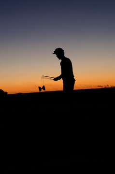 Silhouette of one person playing Diabolo at sunset