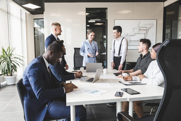 A team of young businessmen working and communicating together in an office. Corporate businessteam and manager in a meeting