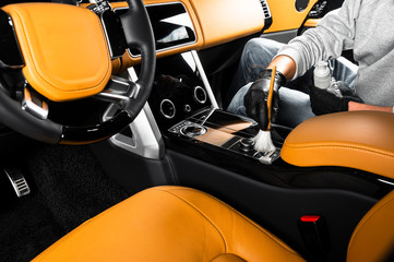 Brush cleaning off dust from the car interior details, close up view