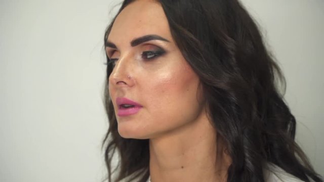 Makeup artist cleans lips model from lipstick. Makeup artist at work