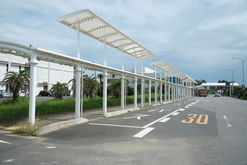 Fototapeta na wymiar Amami Oshima, Japan - June 18, 2019: Bus stops at Amami airport terminal building in Amami Oshima, Kagoshima, Japan
