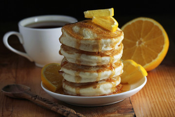 A stack of freshly backed pancakes and a cup of coffee
