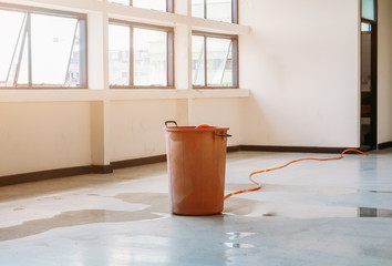 red bucket underlie water leak interior office building in from Ceiling