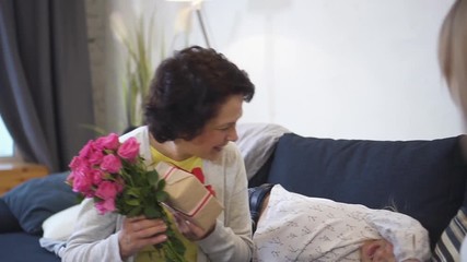 Happy senior grandparent is getting present and lovely rose flower bouquet from daughter and female grandchild. All women are laughing and looking so happy together. Retired smiling grandmother love - Powered by Adobe