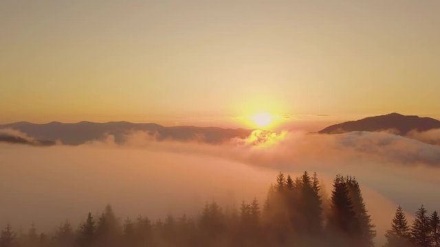 Surreal sunrise in the Smoky mountain skies. Drone video lifting up and panning to reveal the sunrise through the clouds in the Blue Ridge Great Smoky Mountains of Tennessee