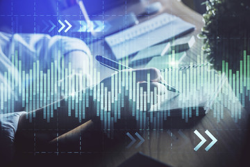 Financial forex charts displayed on woman's hand taking notes background. Concept of research. Double exposure