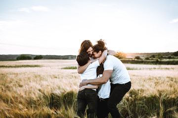 Happy family hugging in the field and smiling. Family in a sunset