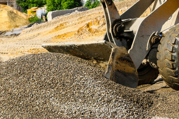  tractor collects scoop with  gravel. excavator extracts sand and gravel for  concrete mix.