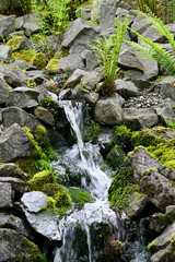 Small waterfall among stones outdoors in nature.