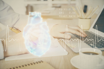Heart drawing with man working on computer on background. Medical concept. Double exposure.