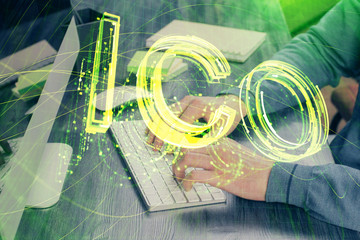 Crypto currency theme hologram with businessman working on computer on background. Concept of...