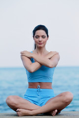 Fototapeta na wymiar Jeune femme faisant son Yoga face à la mer