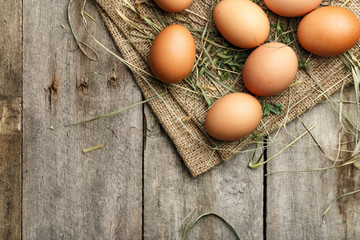 Many eggs lie on the background of hay