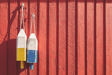 Fishing buoys on red wooden wall, horizontal