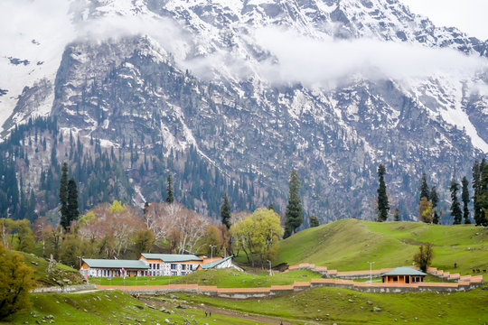 Stunning photograph of Kashmir valley (Paradise on Earth). Beautiful view of Betaab Valley surrounded by snow frozen Himalayas glacier mountains and green fir and pine tree line forest landscape.