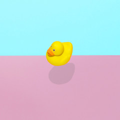 Rubber duck toy flies in the air with a strong shadow.