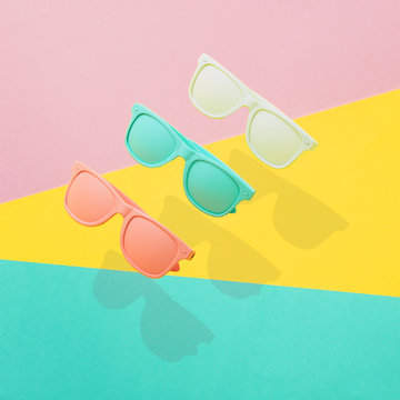  Three painted sunglasses fly in the air with a strong shadow.