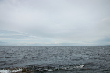 Grey sea water with horizon and greyish blue sky. Calm seascape