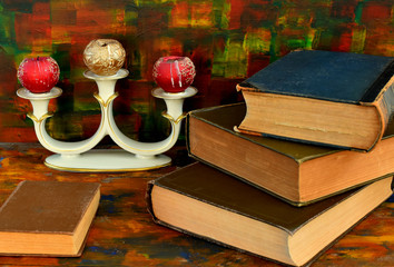 Still life - bronze candlestick and old books.Old wooden table.