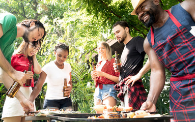 Group of people toasting beers celebration and having barbecue party outdoors garden