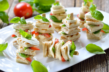Caprese-Häppchen: Spießchen mit gegrilltem Bruschettabrot mit Mozzarella, Tomaten und Basilikum -Toasted Italian bread with buffalo cheese, tomatoes and basil on wooden skewers 