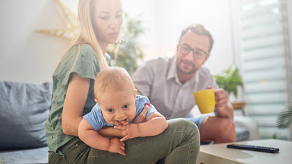 Obraz premium Parents playing with a baby at home.
