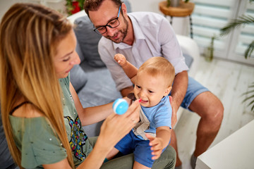 Parents playing with a baby at home.