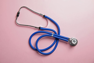 Stethoscope on color background, top view. Medical tool