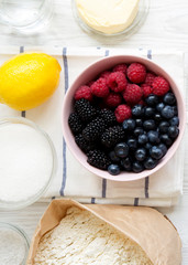 Raw ingredients: berries, lemon, flour, sugar, salt, water for cooking berry pie, top view. From above, overhead, flat lay. Close-up.